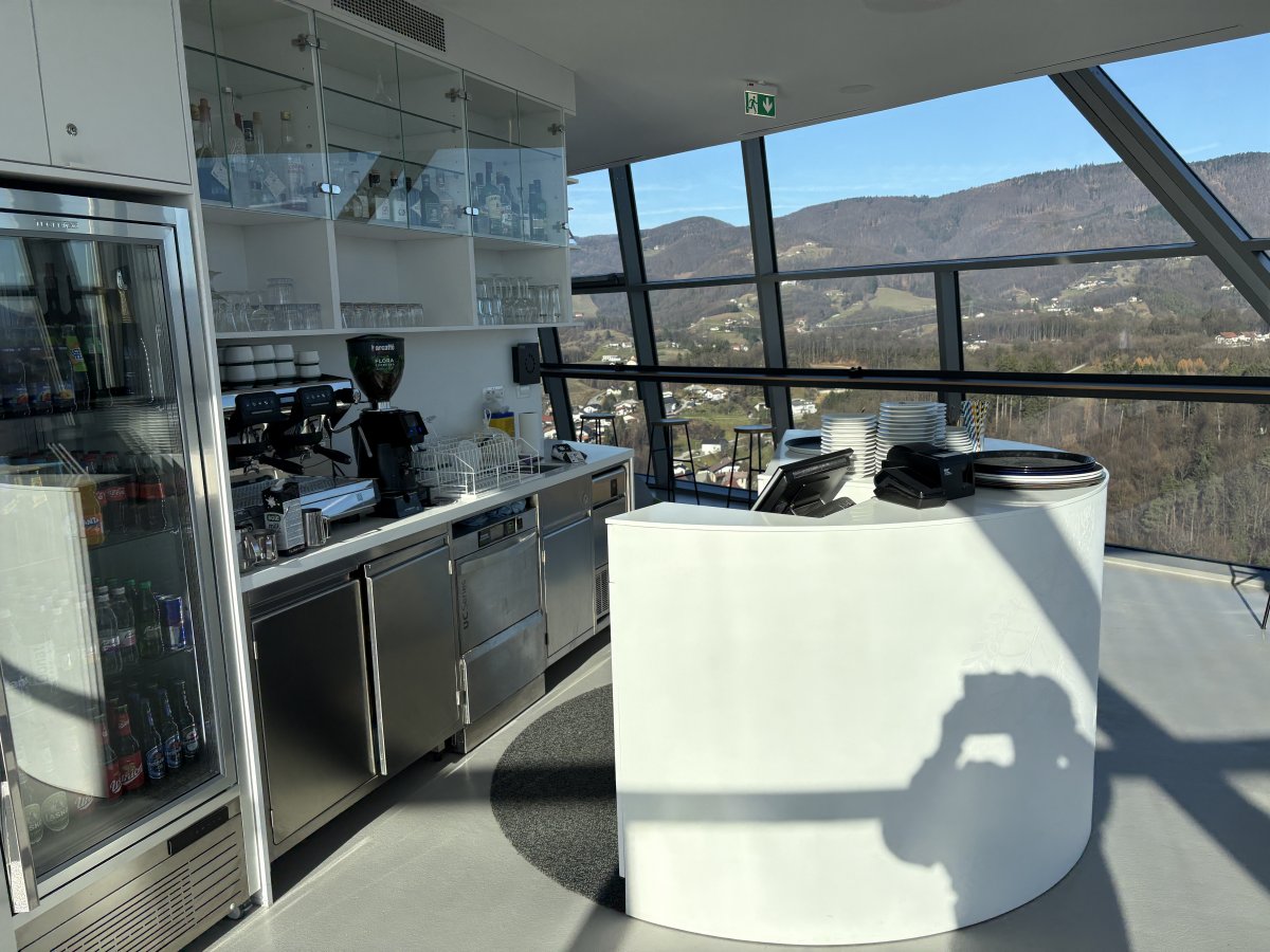 Modern cafe with plenty of tables inside at the top of the tower..