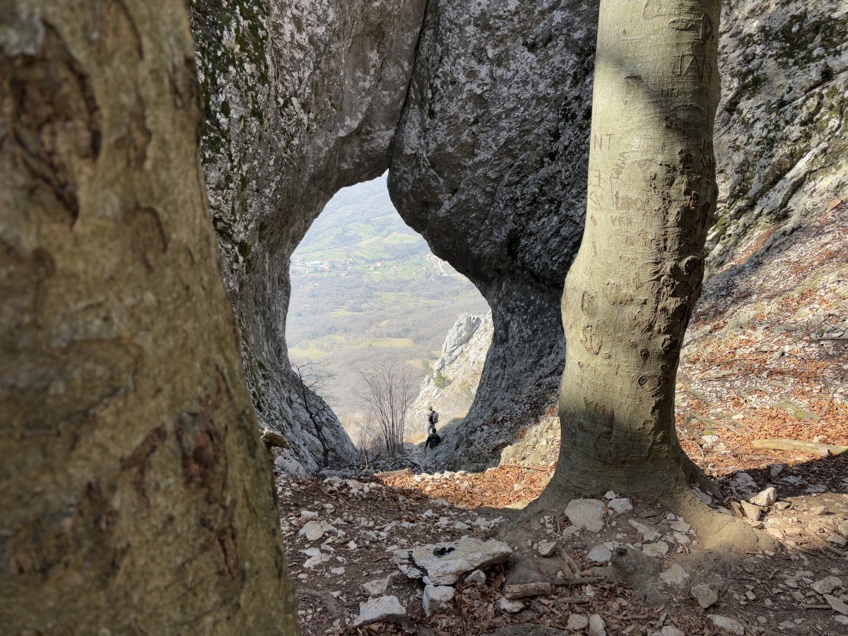 The two hikers expose the massive scale of this giant natural rock window looking 1,000m down into the Vipava Valley.. The two hikers expose the massive scale of this giant natural rock window looking 1,000m down into the Vipava Valley..