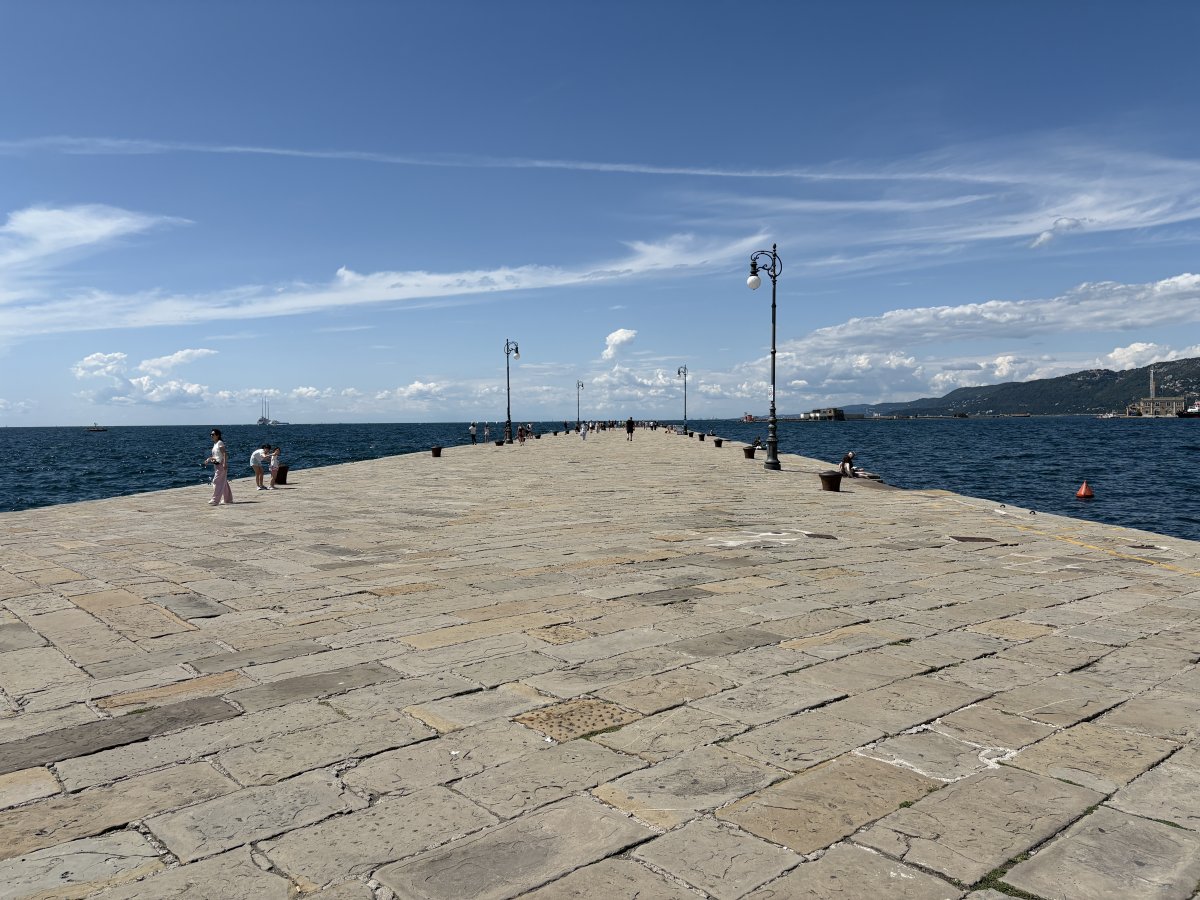 Trieste.. Huge stone pier leads out into the sea.. Miramare Castello is in the distance.. Trieste.. Huge stone pier leads out into the sea.. Miramare Castello is in the distance..